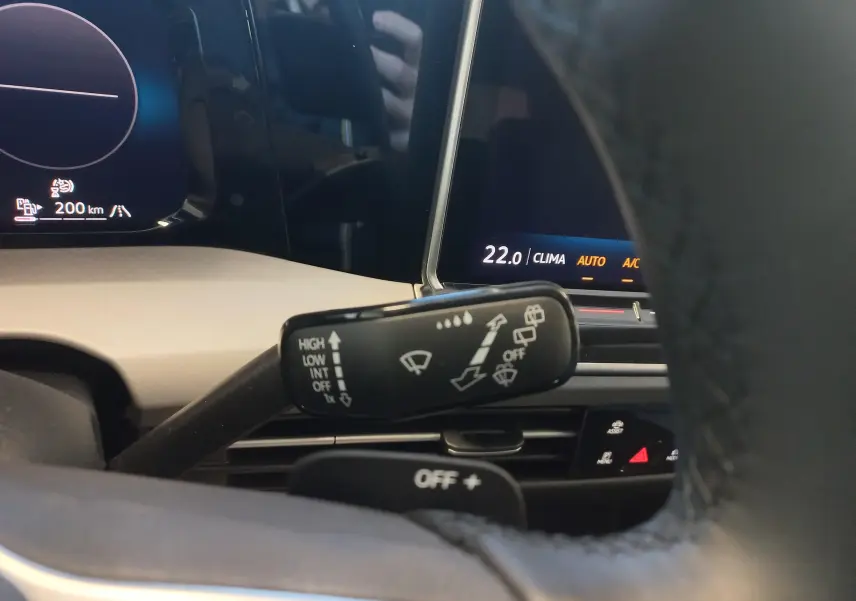 Gros plan sur la commande d’essuie-glace à gauche du volant dans l’habitacle d’une Volkswagen Golf 1.5 eHybrid 2025 argent Dolomite.