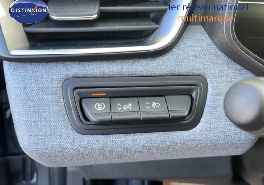 Détail intérieur montrant les commandes d’éclairage et de verrouillage sur tissu gris dans une Renault Clio 2025.