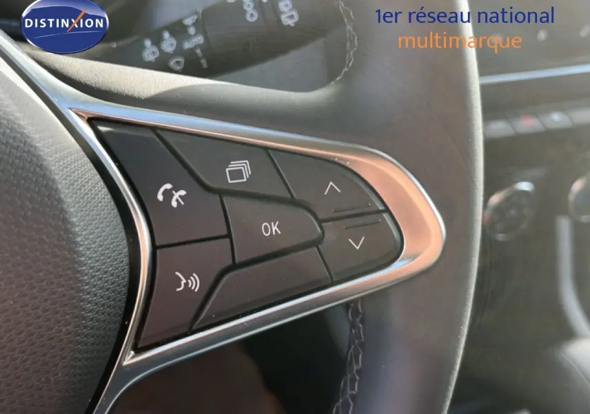 Gros plan sur les commandes multifonctions à gauche du volant cuir noir de la Renault Clio 2025, boutons noirs et chrome.