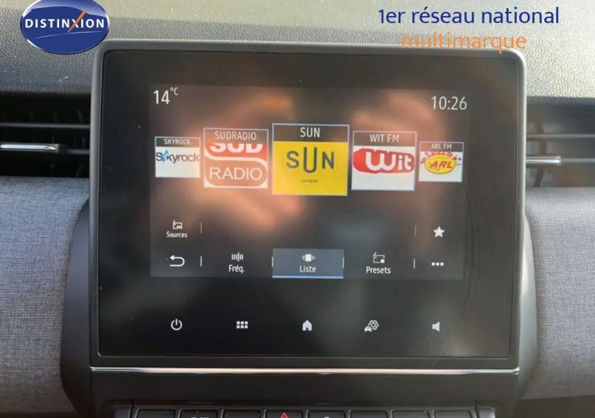 Écran tactile central de la Renault Clio 2025 gris schiste, affichant les stations radio avec commandes en dessous.