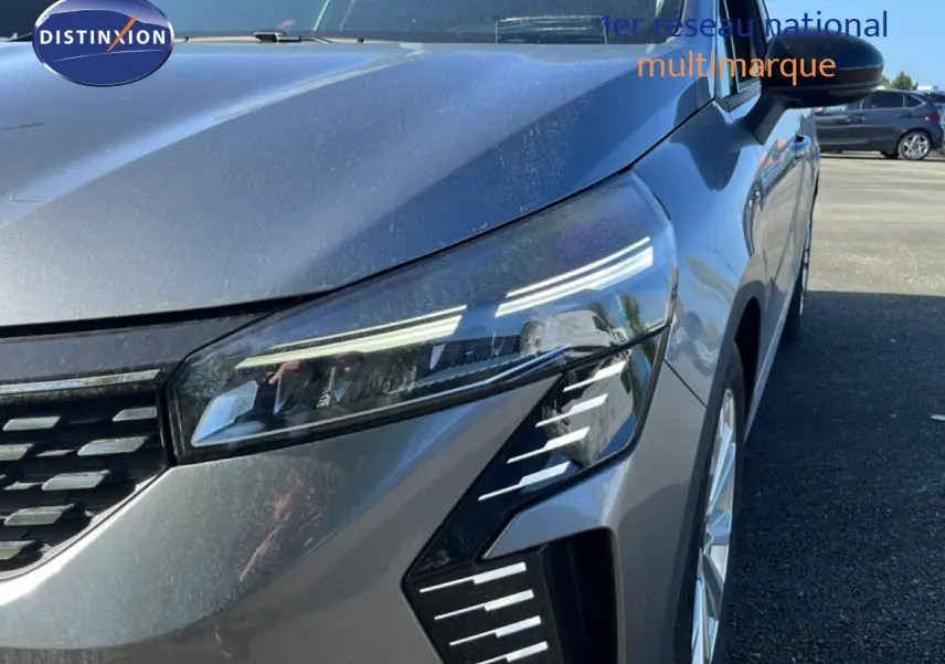Vue avant droite rapprochée d’une Renault Clio gris schiste métal mettant en valeur ses phares LED distinctifs.