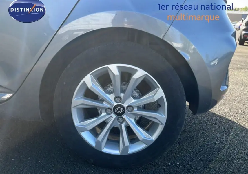 Gros plan sur la roue avant droite d'une Renault Clio gris schiste métal, mettant en valeur la jante alu moderne.