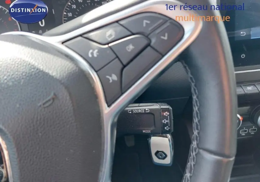 Vue rapprochée du volant de la Renault Clio V SCe 75 Business 2020 avec commandes audio intégrées et tableau de bord partiel.