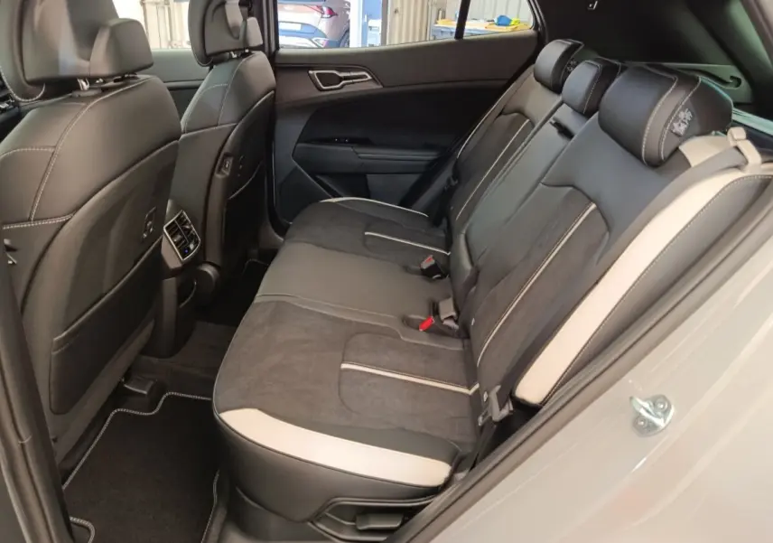 Vue intérieure côté gauche montrant la banquette arrière gris clair et noir du Kia Sportage 2026 GT-Line.