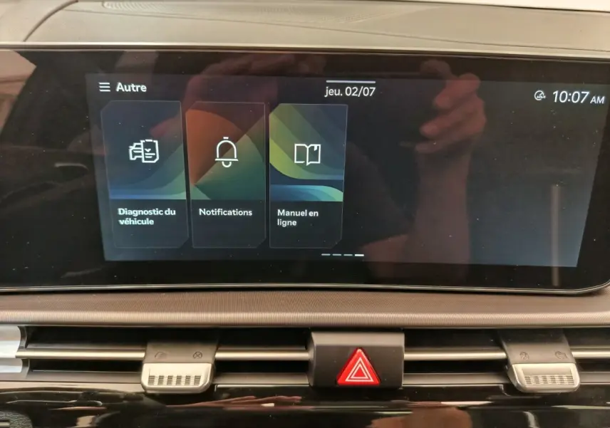 Écran tactile central affichant le menu diagnostic et notifications dans le tableau de bord du Kia Sportage gris clair.