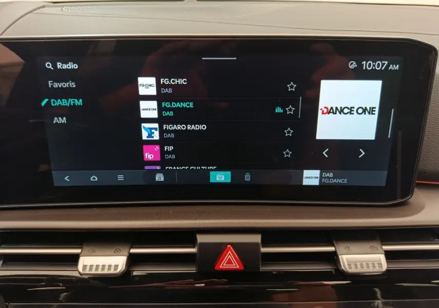 Écran tactile central du tableau de bord du Kia Sportage gris clair, affichant les options radio DAB/FM.