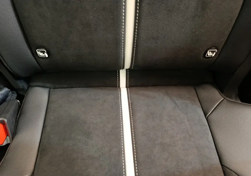 Gros plan sur la banquette arrière noire avec surpiqûres blanches et fixations ISOFIX visibles du KIA Sportage 2026.