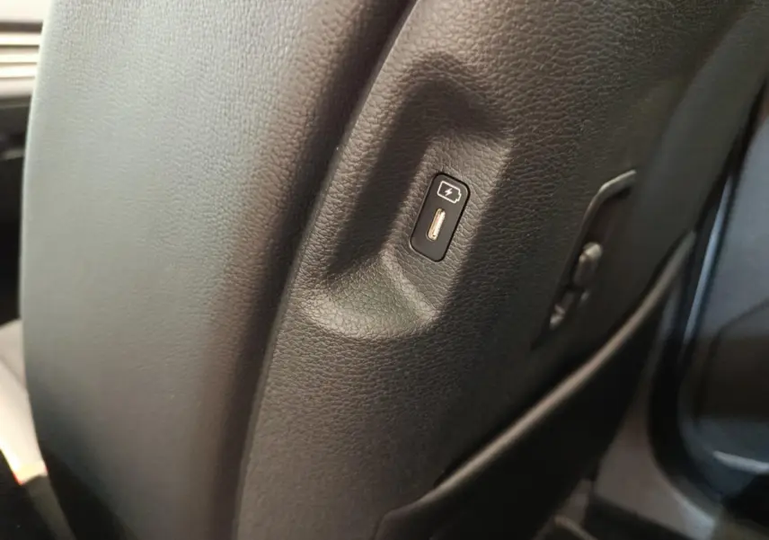 Prise USB intégrée sur le côté droit du siège avant en cuir noir du Kia Sportage gris clair 2026.