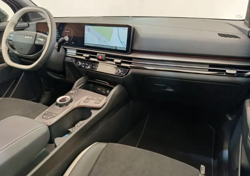 Vue intérieure de face droite du tableau de bord noir et gris avec écran tactile large et volant KIA clair du Kia Sportage 2026.