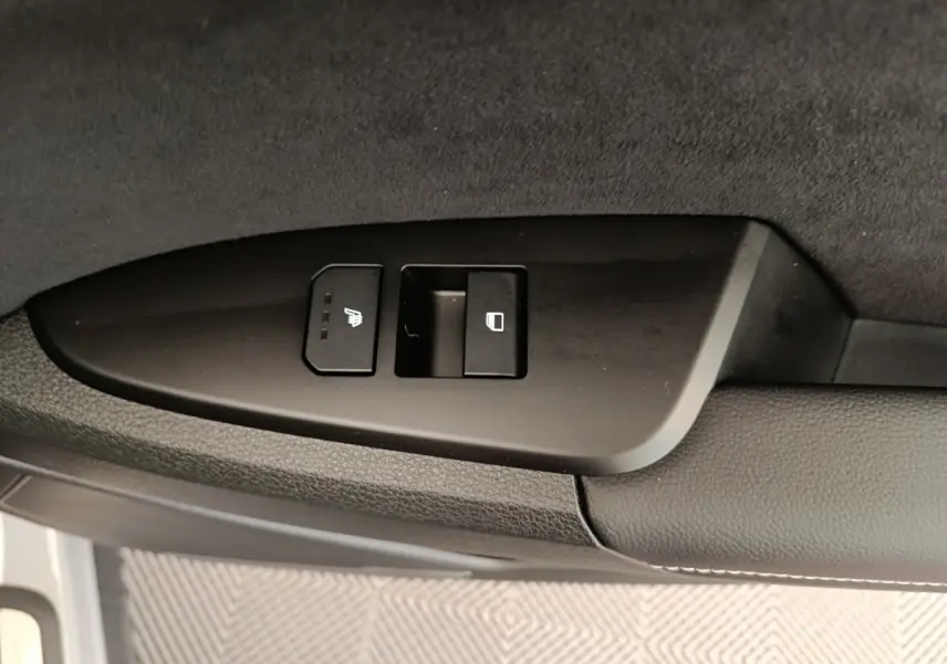 Gros plan sur les commandes de verrouillage et siège chauffant côté porte avant d’un Kia Sportage gris clair 2026.