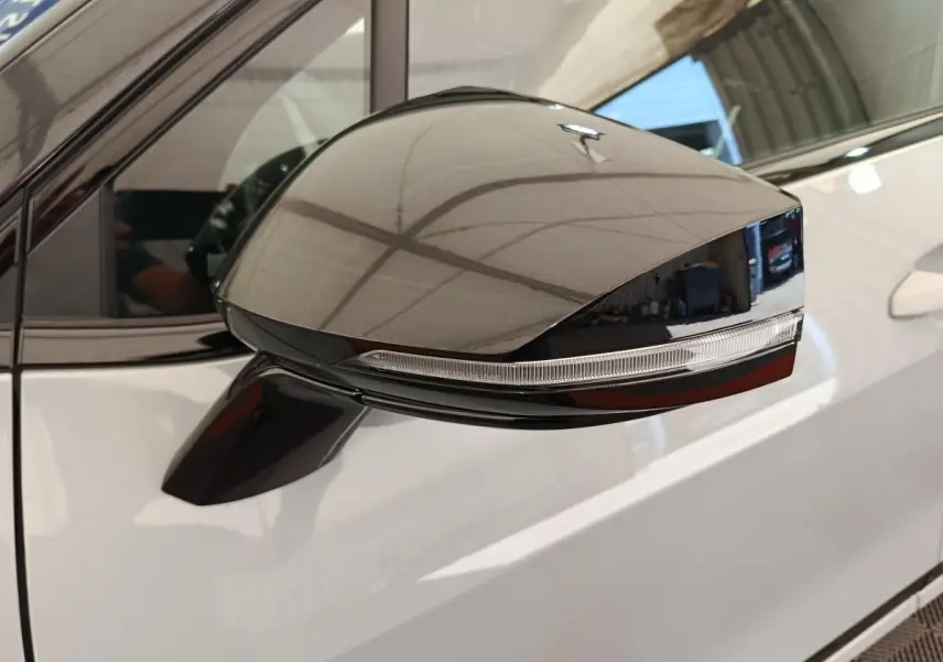 Rétroviseur extérieur noir sur porte gris clair d'un KIA Sportage 2026, vue latérale rapprochée côté gauche.