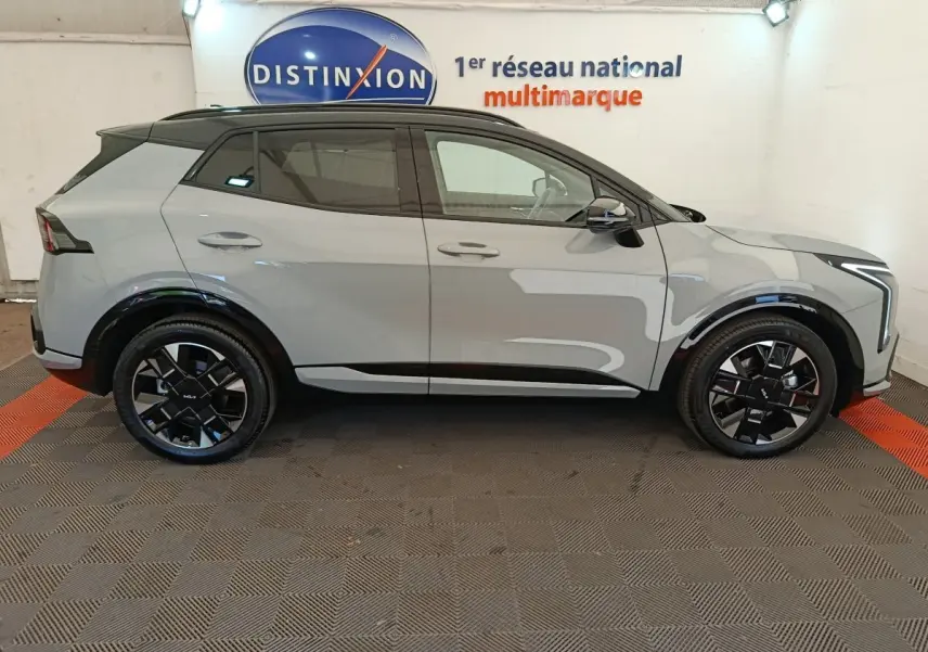 Vue de profil côté gauche du KIA SPORTAGE 1.6 T-GDI 239 HEV AUTO GT-LINE gris clair avec jantes noires et toit noir.