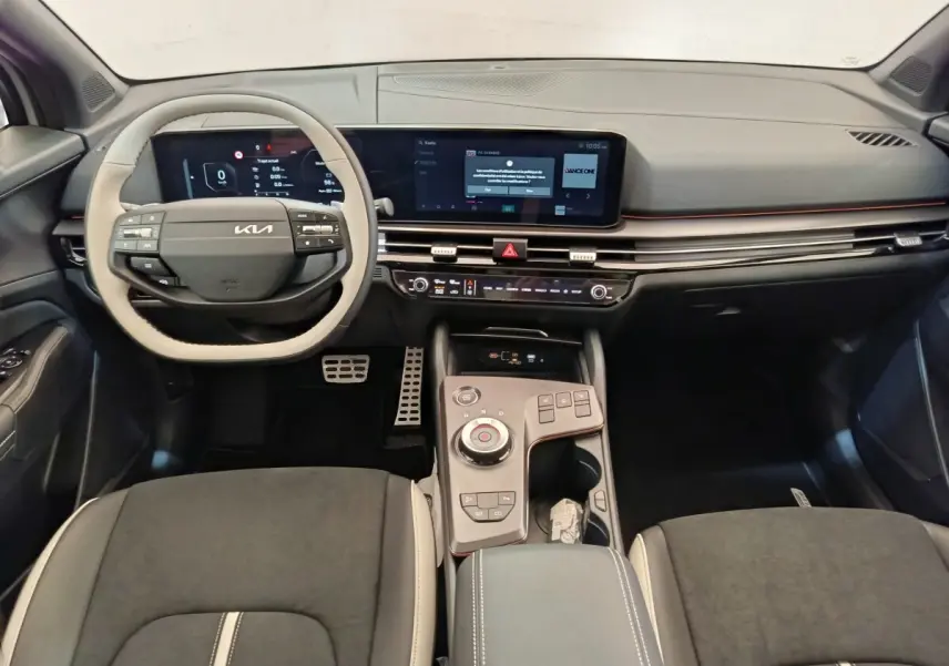 Vue intérieure avant du Kia Sportage 2026 gris clair, avec tableau de bord numérique et console centrale moderne.