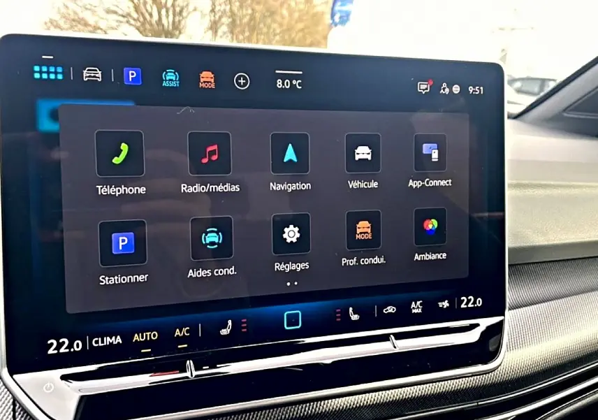 Écran tactile central de la Volkswagen Golf 2026 affichant les options de navigation et multimédia, intérieur noir.
