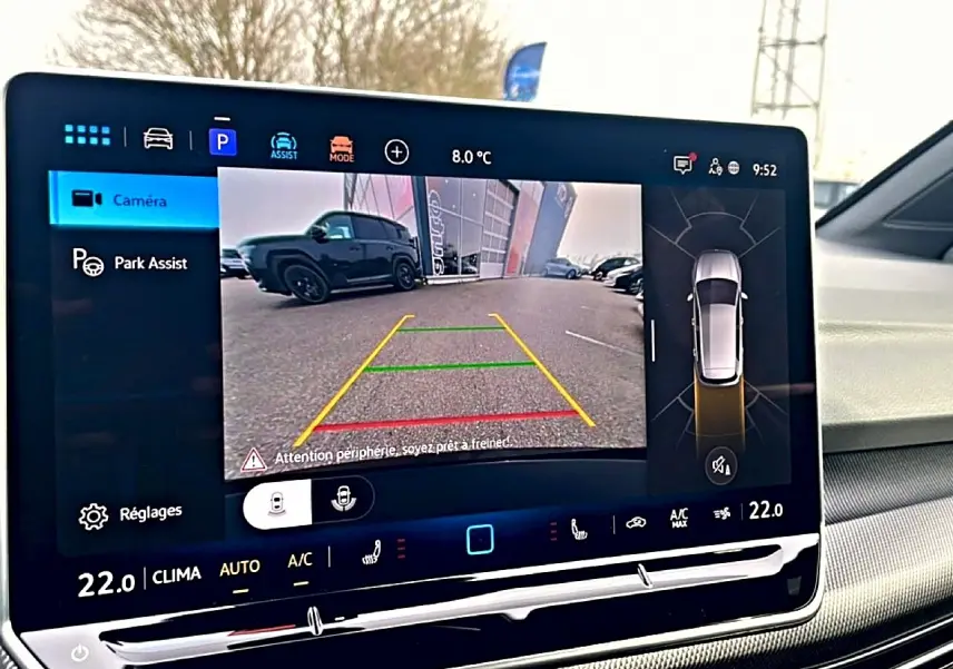 Écran tactile intérieur montrant la caméra de recul et l’aide au stationnement d’une Volkswagen Golf noire.