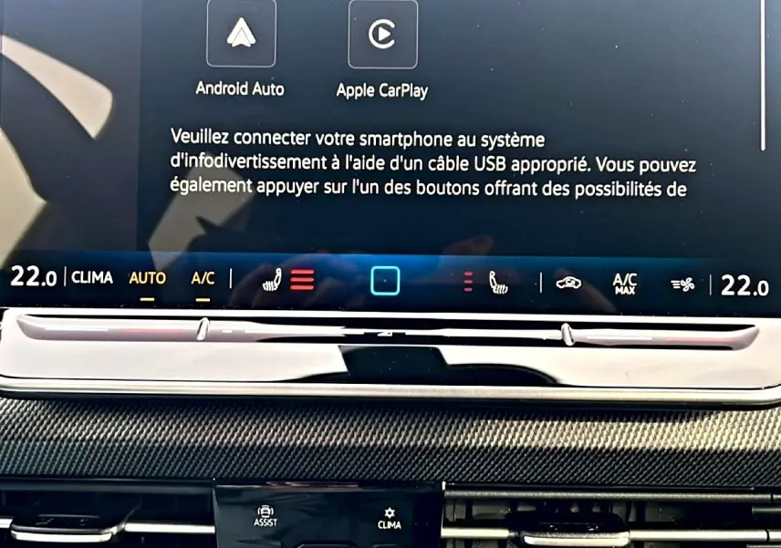 Gros plan sur l'écran tactile central et la console de la Volkswagen Golf 1.5 ETSI Evo2 R-Line noire, avec commandes climatisation et infotainment.