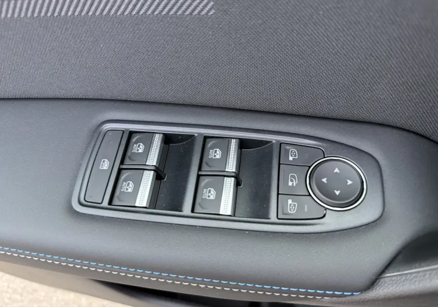 Gros plan sur les commandes des vitres et rétroviseurs côté gauche d'une Renault Captur 2025 noir étoile toit gris.