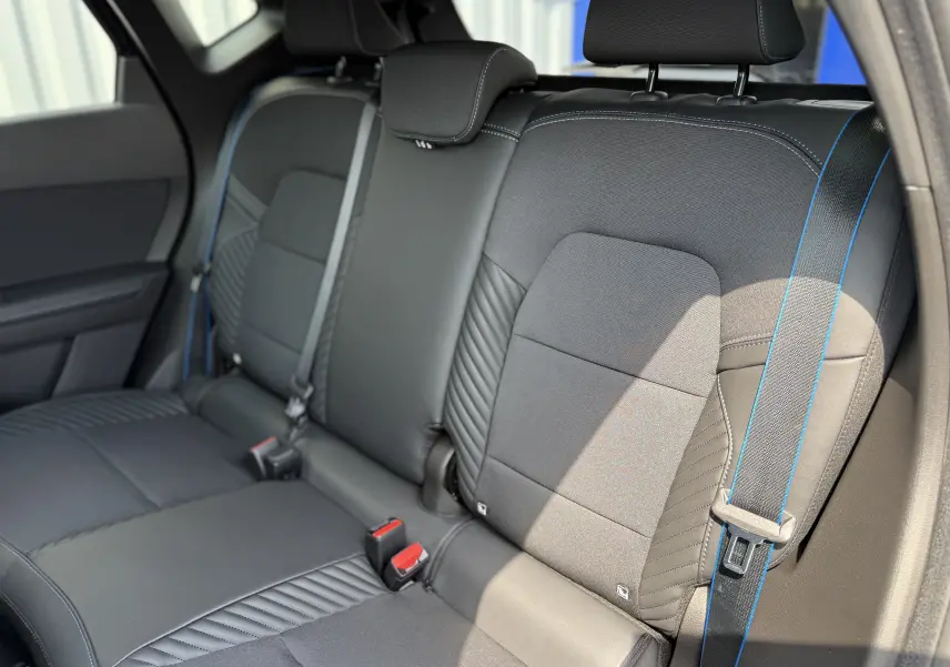 Vue intérieure des sièges arrière noirs avec surpiqûres bleues du Renault Captur 2025 finition Esprit Alpine.