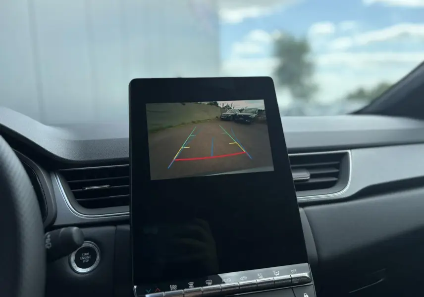 Vue intérieure du tableau de bord du Renault Captur gris Rafale, écran affichant la caméra de recul avec guidage coloré.