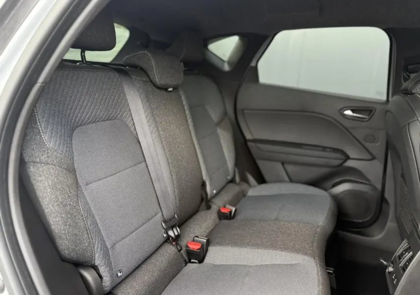 Vue intérieure côté droit des sièges arrière gris foncé du Renault Captur 2025 avec ceinture de sécurité et appuis-tête.