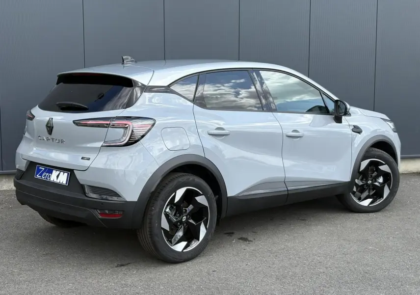 Vue 3/4 arrière droite du Renault Captur Gris Rafale 2025 avec jantes noires et toit gris Highland.