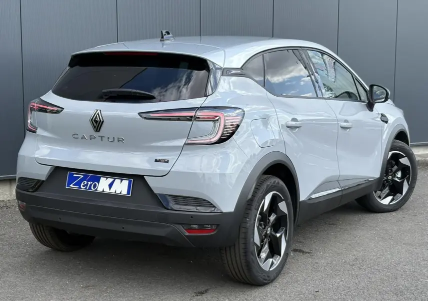 Vue 3/4 arrière droit d'un Renault Captur Gris Rafale avec jantes noires et vitres surteintées.