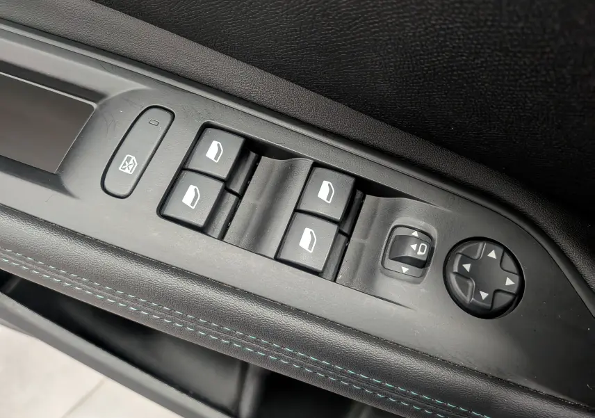 Gros plan sur les commandes des vitres et rétroviseurs côté conducteur du Peugeot 3008 noir Perla, finition Allure.