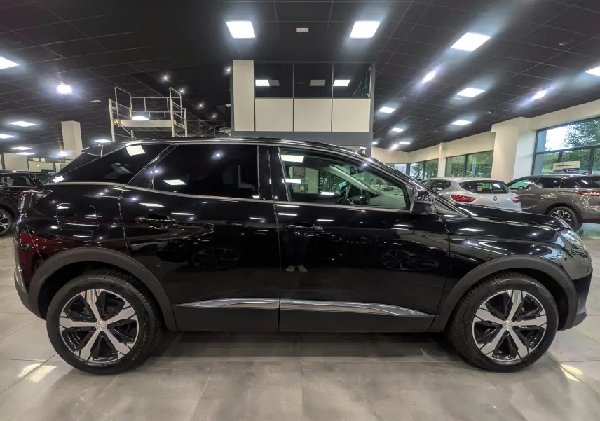 Profil latéral droit d'un Peugeot 3008 BlueHDi 130 Allure noir Perla avec jantes alliage bicolores en showroom.