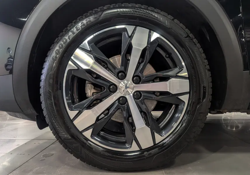 Gros plan sur la jante bi-ton noire et argentée du Peugeot 3008 Noir Perla, pneu Goodyear visible.