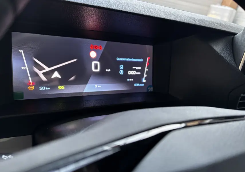 Gros plan sur le tableau de bord numérique du Peugeot Expert Fourgon blanc, affichant la consommation et la vitesse à 0 km/h.
