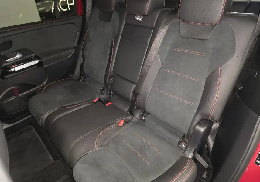 Vue intérieure côté gauche des sièges arrière en similicuir noir avec surpiqûres rouges du Mercedes GLB 200 d AMG Line rouge Patagonie