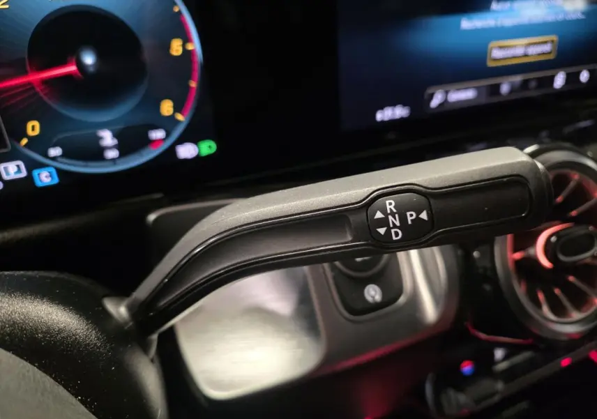 Le levier de boîte automatique noir du Mercedes GLB 200 d AMG Line, avec instrumentation digitale et éclairage d'ambiance rouge.