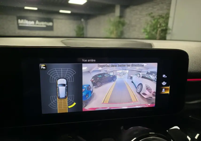 Affichage de la caméra de recul et capteurs de stationnement du Mercedes GLB rouge AMG Line vu de l'intérieur.