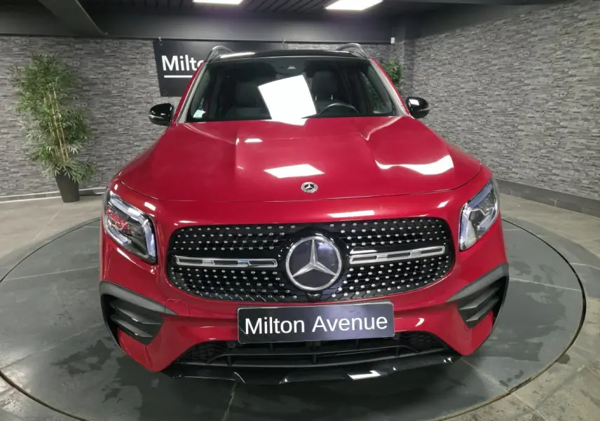 Vue avant d'un Mercedes GLB 200 d AMG Line rouge Patagonie avec calandre diamant et plaques Milton Avenue.