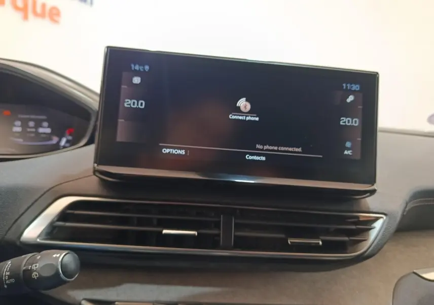 Gros plan sur l’écran tactile central noir du tableau de bord du Peugeot 5008 bleu, affichant la connexion Bluetooth.