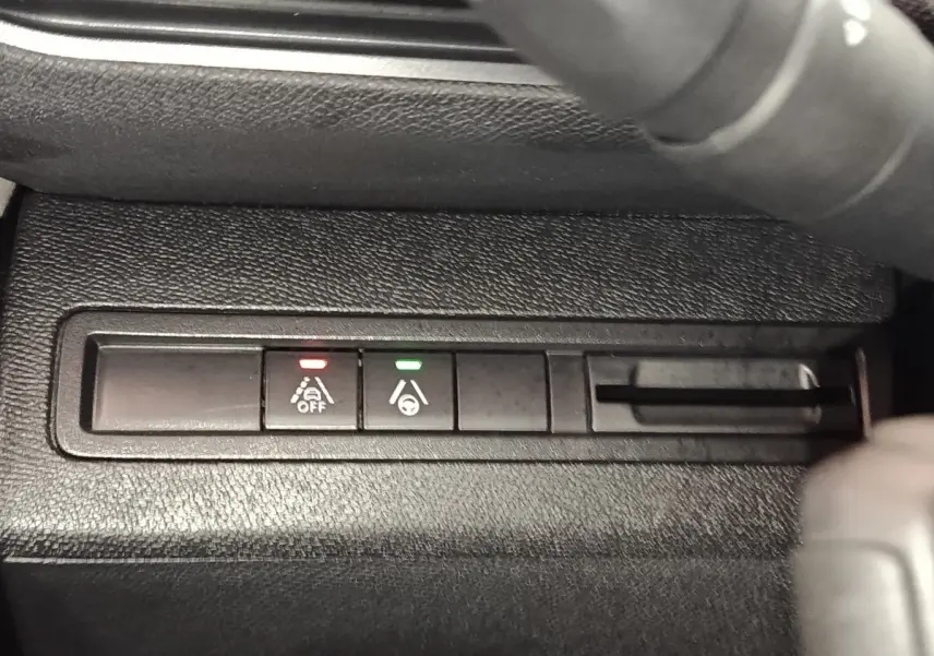 Gros plan sur les boutons d'aide à la conduite du Peugeot 5008 GT 2023, avec voyants rouge et vert allumés.
