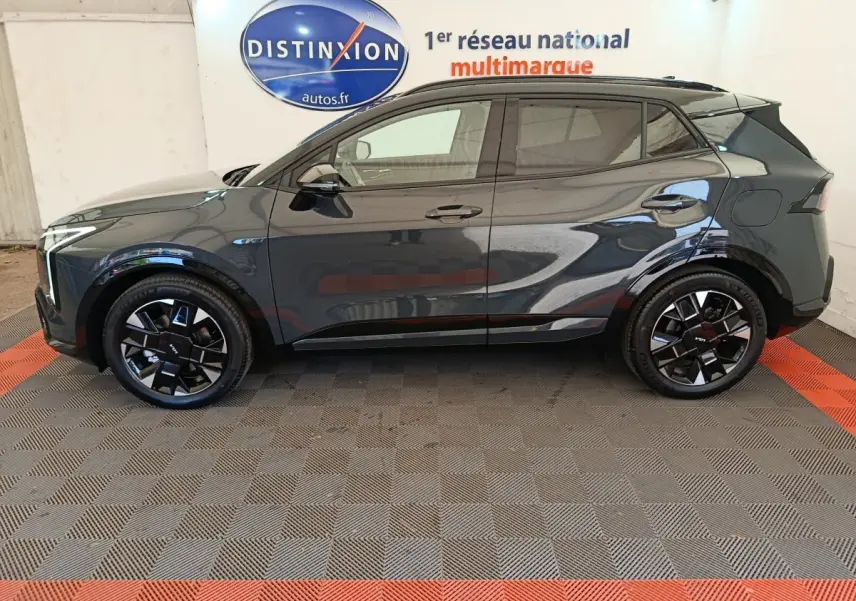 Vue latérale droite du KIA SPORTAGE gris foncé 2026 avec jantes noires au design moderne et toit noir contrasté.
