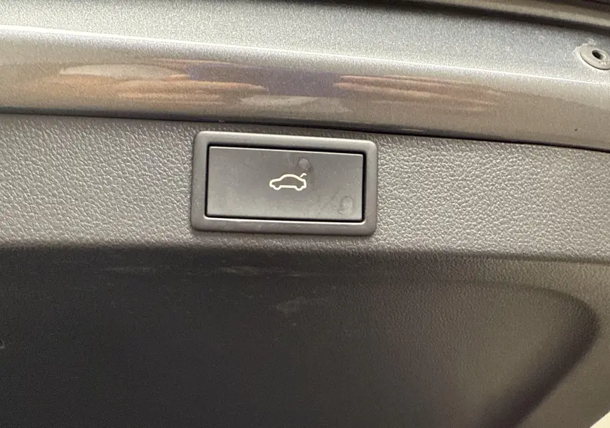 Bouton d'ouverture électrique du hayon sur le coffre gris graphite d'une Skoda Octavia Combi 2023.