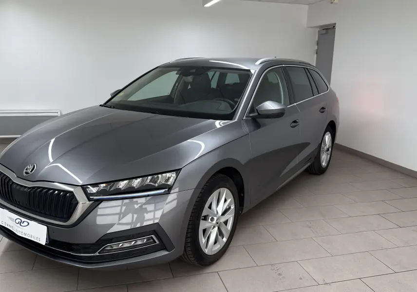 Skoda Octavia Combi gris graphite vue 3/4 avant droit dans un intérieur épuré, finition Style 2023.