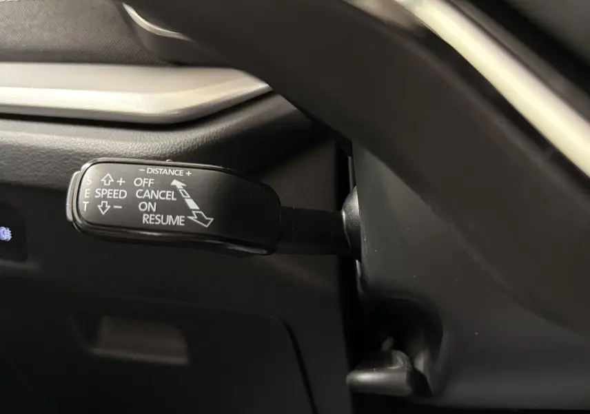 Le levier de régulateur de vitesse sur le côté gauche du volant d'une Skoda Octavia Combi 2023 gris graphite.