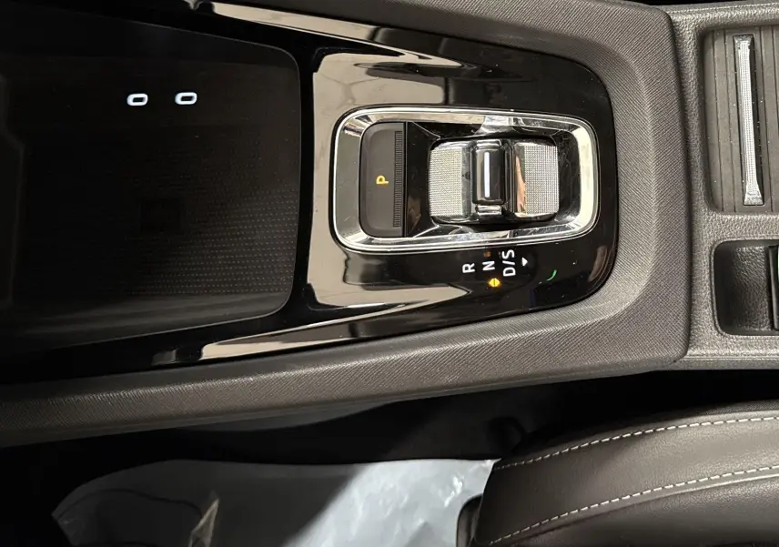Vue rapprochée de la console centrale noire de la Skoda Octavia Combi 2023 avec levier de vitesses automatique et frein à main électrique.