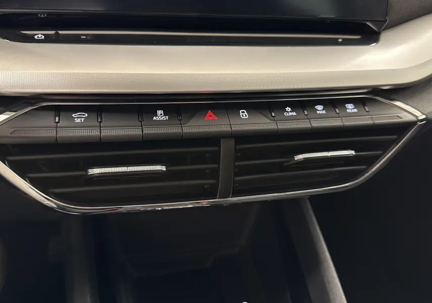 Gros plan sur la console centrale de la Skoda Octavia Combi gris graphite 2023, boutons de climatisation et assistances visibles.