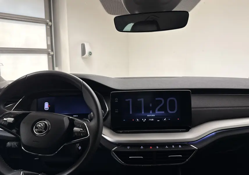 Vue intérieure du tableau de bord de la Skoda Octavia Combi gris graphite, avec écran tactile et volant multifonction.