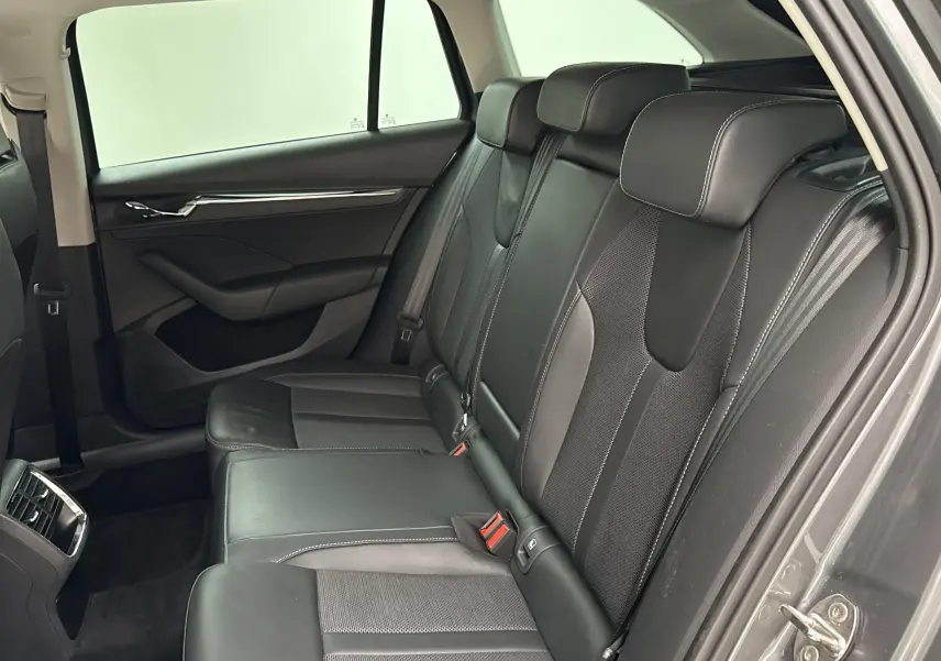 Vue intérieure côté droit des sièges arrière en cuir noir du Skoda Octavia Combi gris graphite 2023.