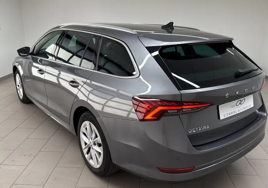 Skoda Octavia Combi gris graphite vue 3/4 arrière droit avec feux LED et barres de toit visibles