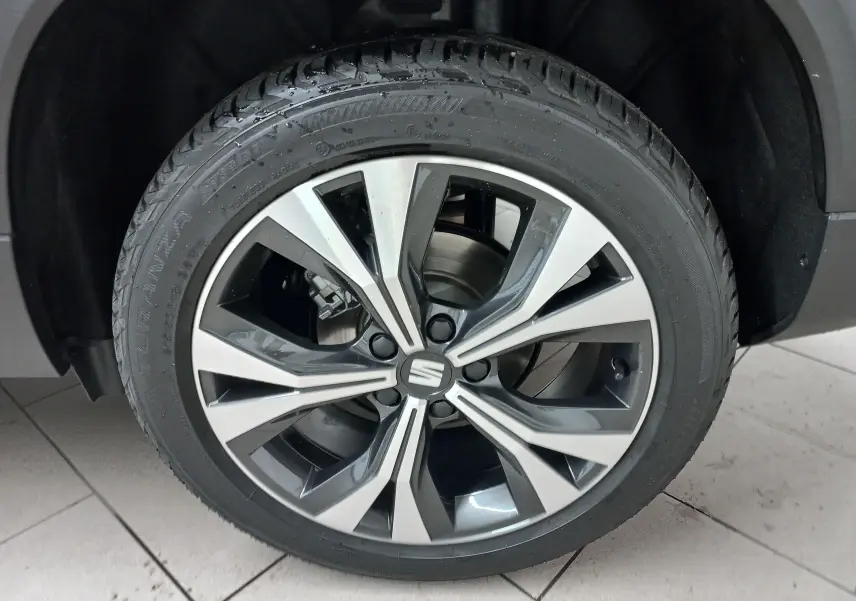 Gros plan sur la jante alliage 18'' usinée du SEAT Ateca noir Magic Nacré, mettant en valeur son design moderne.