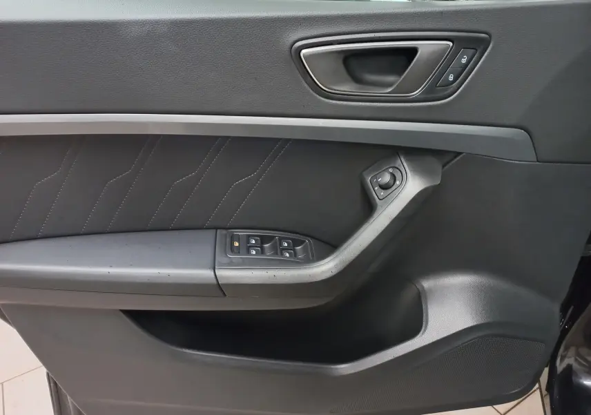 Gros plan sur la porte intérieure côté conducteur du SEAT Ateca noir avec commandes de vitres et verrouillage.