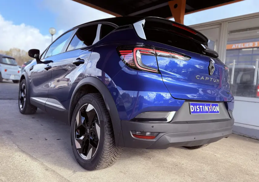 Vue 3/4 arrière droite du Renault Captur 2025 bleu Iron Metal avec toit noir et jantes noires distinctives.