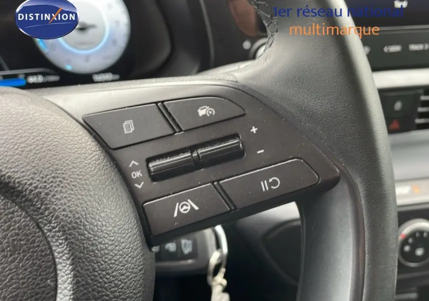 Gros plan sur les commandes au volant en cuir noir de la Hyundai i20 2025, soulignant les boutons multifonctions.