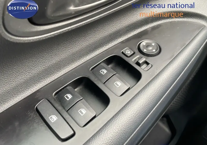 Gros plan sur les commandes des vitres électriques côté conducteur d'une Hyundai i20 noire Phantom Metal 2025.